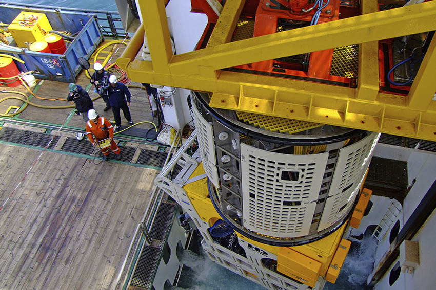 Crew members on a ship with modern day machinery, during a trip to recover the cargo.