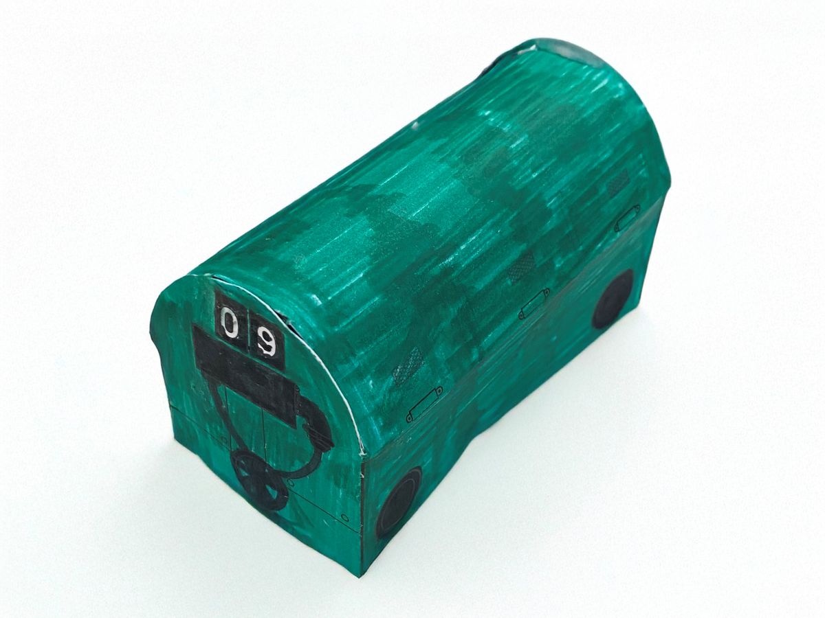 A green paper model of a Mail Rail train.