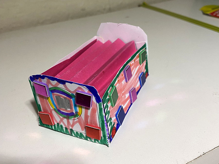 A colourful pink paper model of a Mail Rail York trolley.